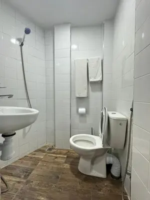 a white bathroom with a toilet and a sink at Gîte - Auberge PYRAMIDES Bab Boudir in Bab Boudir