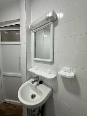 a white bathroom with a sink and a mirror at Gîte - Auberge PYRAMIDES Bab Boudir in Bab Boudir