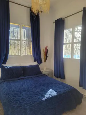 a bedroom with a blue bed with blue curtains at Ourika Valley Haven - Breathe, Relax, Unwind in Ourika