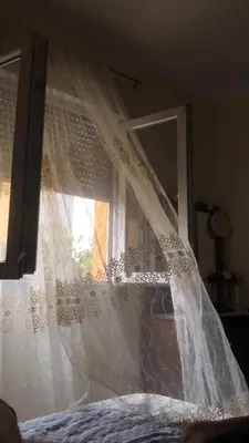 a window with a white curtain on top of a bed at aLO MARRAKECH in Kasba Aït Youdi