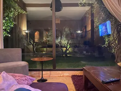 a living room with a view of a living room with a table at Villa les Portes de l'Atlas - MARRAKECH in Marrakech