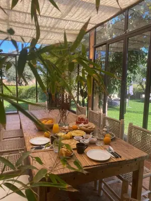 a wooden table with plates of food on it at Villa les Portes de l'Atlas - MARRAKECH in Marrakech