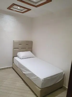a bed in a room with a white wall at Dar diafa in Imouzzer Kandar