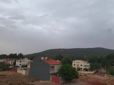 a town with houses and a mountain in the background at Dar diafa in Imouzzer Kandar