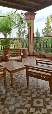 a group of benches sitting on top of a patio at Villa Hamza Marrakech in Bou Touil