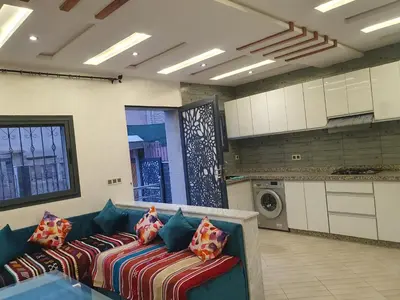 a living room with a blue couch with pillows at Guest house in Imouzzer Kandar
