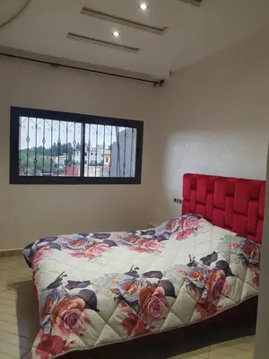 a bed with a red head board in a room at Guest house in Imouzzer Kandar