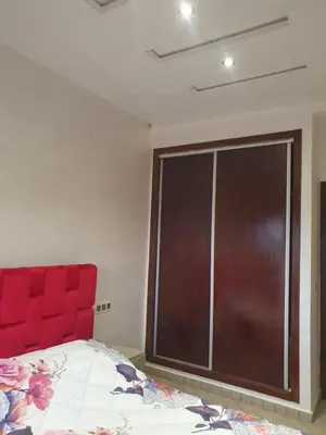 a bedroom with a red headboard and a large window at Guest house in Imouzzer Kandar