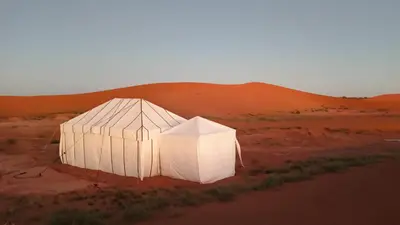 a white tent in the middle of the desert at Akwabir camp in El Gouera