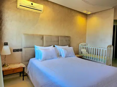 a bedroom with a large bed with blue pillows at Havre chic au cœur du centre-ville, à deux pas de la gare, espace généreux in Fès