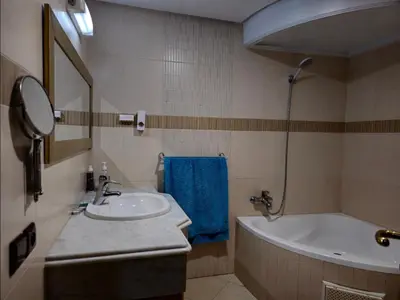 a bathroom with a sink and a bath tub at Havre chic au cœur du centre-ville, à deux pas de la gare, espace généreux in Fès
