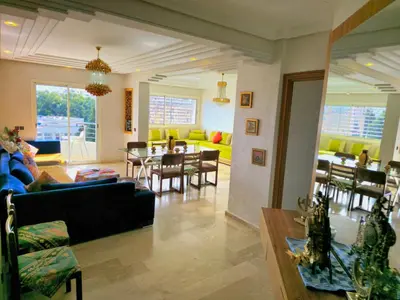 a living room with a couch and a table and chairs at Havre chic au cœur du centre-ville, à deux pas de la gare, espace généreux in Fès