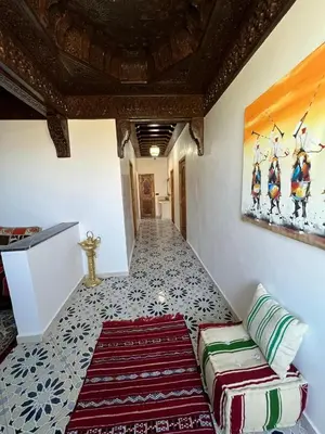 a living room with a couch and a painting on the wall at Villa SANDI in Ouled el guerne
