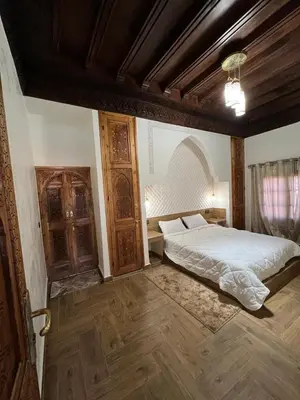 a bedroom with a bed and a wooden ceiling at Villa SANDI in Ouled el guerne