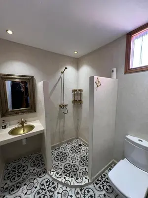 a bathroom with a shower and a sink and a toilet at Villa SANDI in Ouled el guerne
