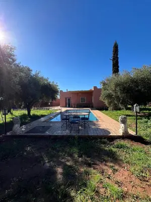 a patio with a table and chairs in a yard at Villa SANDI in Ouled el guerne