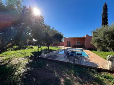 a patio with a table and chairs in a yard at Villa SANDI in Ouled el guerne