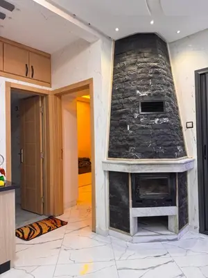 a stone fireplace in a living room with a stone wall at Appartement deux chambres avec parking gratuit in Azrou