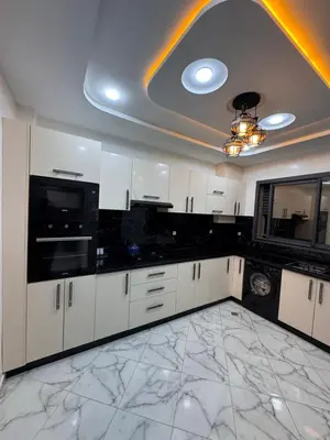 a kitchen with white cabinets and black appliances at Appartement deux chambres avec parking gratuit in Azrou