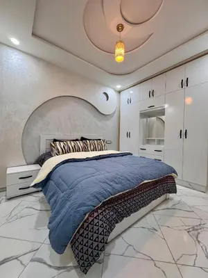 a bedroom with a large bed with a blue blanket at Appartement deux chambres avec parking gratuit in Azrou