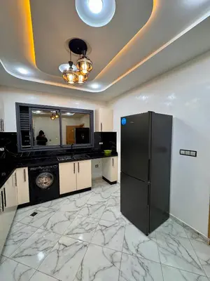 a kitchen with a black refrigerator on a marble floor at Appartement deux chambres avec parking gratuit in Azrou