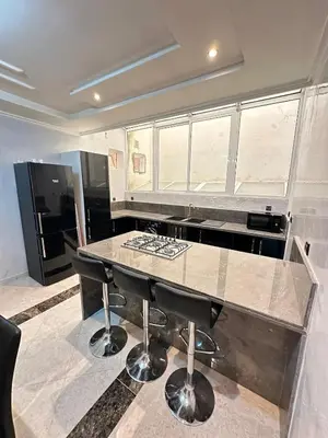 a kitchen with a granite counter top and a table at Fez Spacious Stay with Moroccan Artisanal Charm in Fès