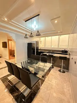 a dining room with a glass table and black chairs at Fez Spacious Stay with Moroccan Artisanal Charm in Fès
