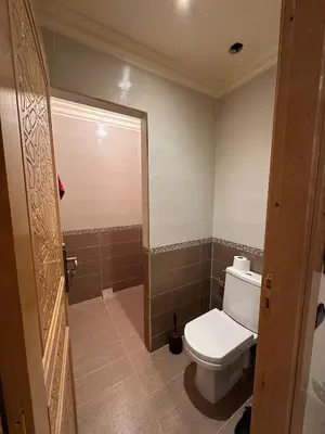 a bathroom with a white toilet and a shower at Fez Spacious Stay with Moroccan Artisanal Charm in Fès