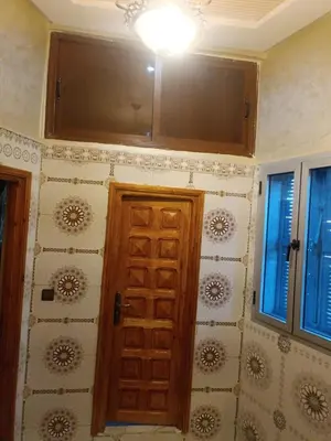 a room with a wooden door and some windows at Appartement Aboumalik in Agdz