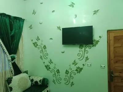 a living room with a television on a wall at Appartement Aboumalik in Agdz