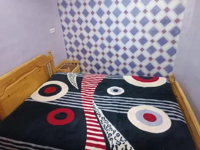 a bed with a black and white comforter with eyes at Appartement Aboumalik in Agdz