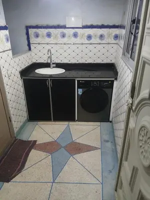 a bathroom with a sink and a washing machine at Appartement Aboumalik in Agdz