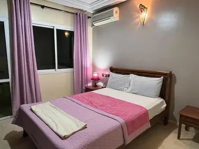 a bedroom with a large bed with a pink blanket at Luxury appartement centre ville fes in Fès