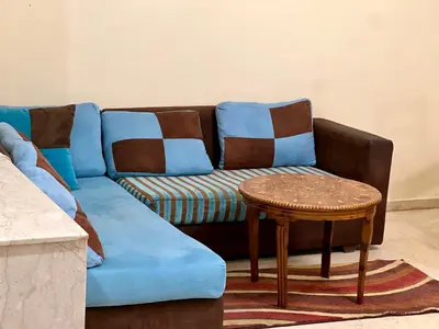a blue couch with a stool and a table at Luxury appartement centre ville fes in Fès