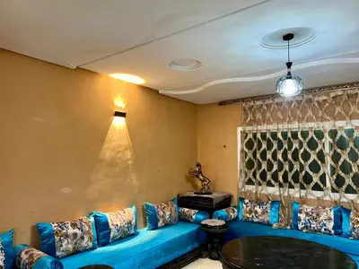 a living room with a blue couch and a table at Luxury appartement centre ville fes in Fès