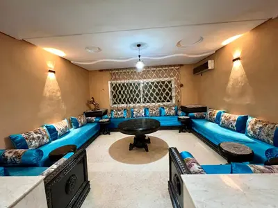 a living room with a blue couch and a table at Luxury appartement centre ville fes in Fès