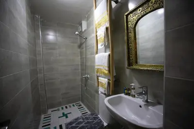 a bathroom with a sink and a shower with a mirror at Dar derb el miter in Fès