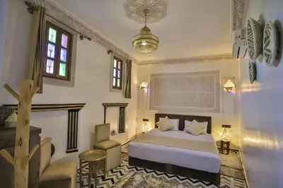 a bedroom with a bed and a chair in it at Dar derb el miter in Fès