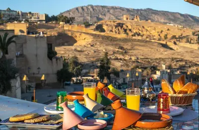 a table with plates of food and glasses of orange juice at Dar derb el miter in Fès