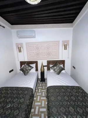 a bedroom with two beds and a lamp in it at Dar derb el miter in Fès