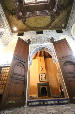a hallway in a building with wooden doors at Dar Na in Station Bab Ftouh