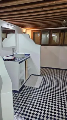 a kitchen with a black and white checkered floor at Dar Na in Station Bab Ftouh