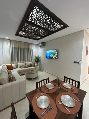 a living room with a table and a couch at Modern apartment near amenities in Fès