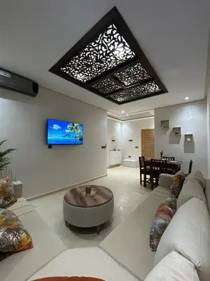 a living room with a couch and a tv on the wall at Modern apartment near amenities in Fès
