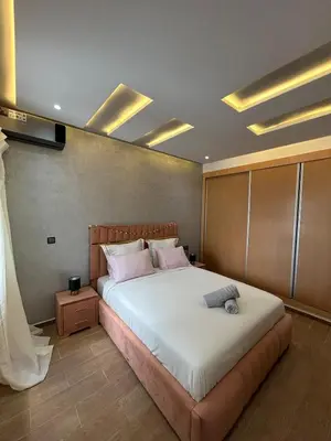 a bedroom with a large bed with pink pillows at Modern apartment near amenities in Fès