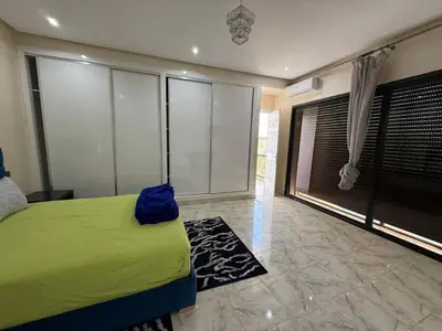 a bedroom with a green bed and a large window at Villa Adam in Srarhna
