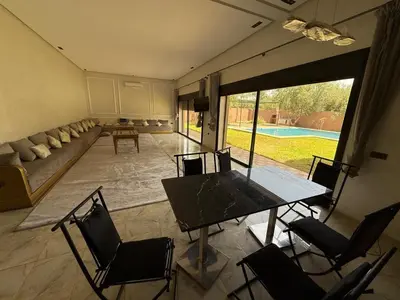 a living room with a table and chairs and a couch at Villa Adam in Srarhna