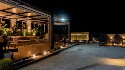 a patio with a table and chairs at night at TheHive Residence in Fès