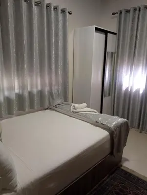 a bed sitting in a room with a window at TheHive Residence in Fès