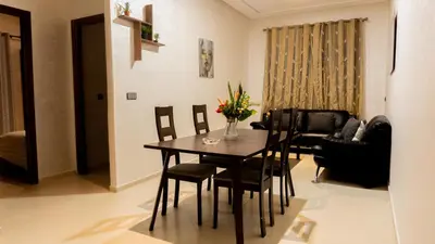 a living room with a dining room table and chairs at TheHive Residence in Fès